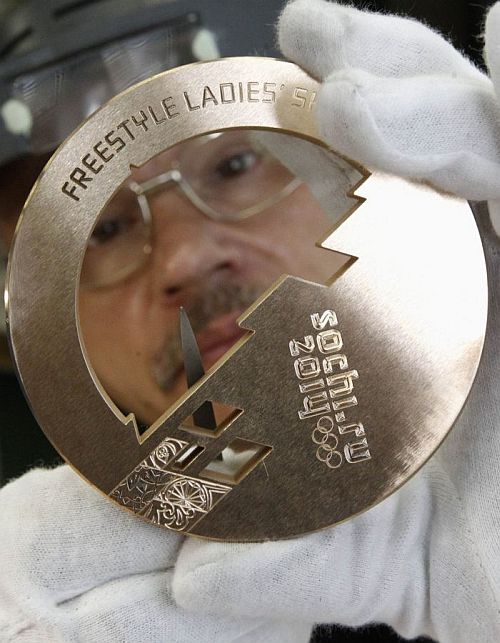 An employee works on a silver medal manufactured for the 2014 Winter Olympic Games in Sochi, at the Adamas jewellery factory in Moscow